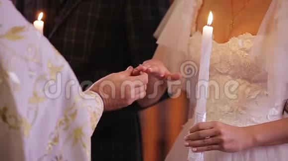牧师双手将结婚戒指戴在新娘手上的特写镜头新婚夫妇在婚礼期间视频的预览图