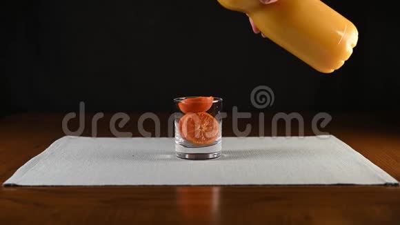 橘子汁被一只装满橘子切片的雄性倒入玻璃中视频的预览图