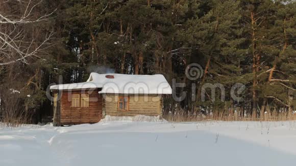雪松林中白雪覆盖的木屋俄罗斯村庄冬季景观视频的预览图