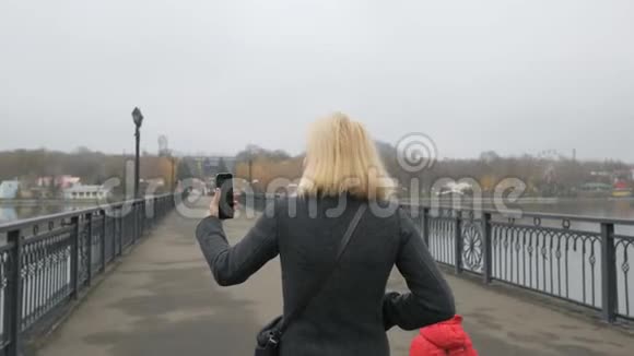 一个女人和她的小女儿走过桥在视频聊天中交谈一个有影响力的人把视频的预览图