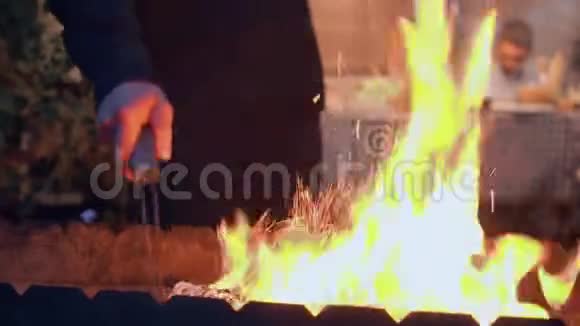 男性手的特写为烧烤特写生火那个准备在户外为公司煮肉的人晚上视频的预览图