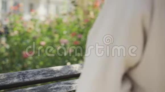 美丽的年轻女子穿着浴袍头上戴着毛巾坐在公园的长凳上戴上眼镜视频的预览图