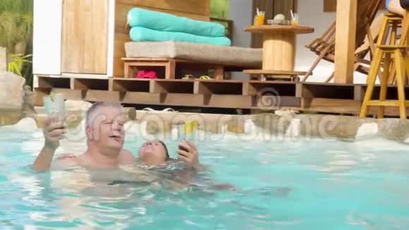 不错的成人情侣放松和享受游泳池视频的预览图
