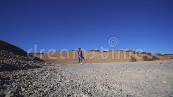 希普斯特女人走过镜头穿过火山沙漠自然干旱的气候静态射击广角射击视频的预览图