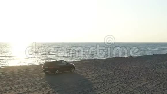 沿着海边沙滩行驶的汽车的鸟瞰图视频的预览图