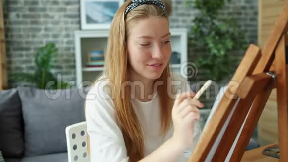 拉拉少年画微笑着用画架和铅笔视频的预览图