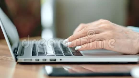 女性手打字键盘的笔记本电脑工作侧视图近距离拍摄4k红色相机视频的预览图