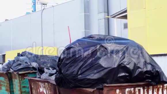 全垃圾容器大黑袋的垃圾在风特写靠近一个工业建筑环境视频的预览图