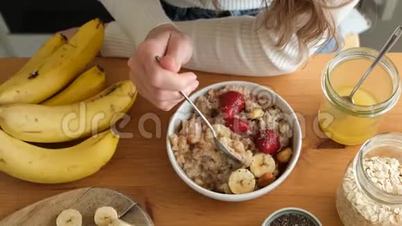 女人早餐吃麦片粥和水果坚果视频的预览图