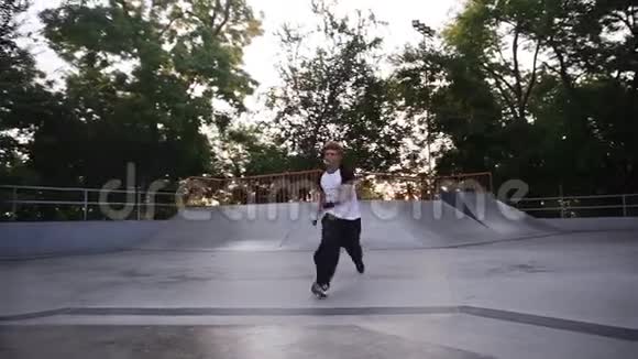 白天在溜冰场玩跑酷把戏的年轻人弗莱伦纳男子表演各种跳跃特技表演视频的预览图