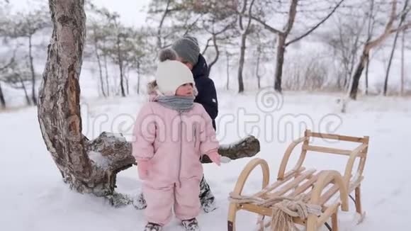 穿着连衣裙的男孩和小女孩在雪天滑雪后玩得很开心哥哥姐姐过寒假视频的预览图