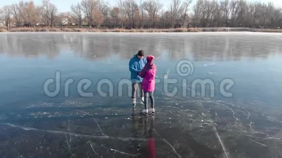一对快乐的夫妇在一个可爱的阳光明媚的冬日在冰冻的湖面上户外滑冰滑冰可爱的情侣冬天来了视频的预览图