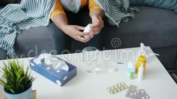 年轻女性在家中使用药物从瓶子里取药丸时动作缓慢视频的预览图