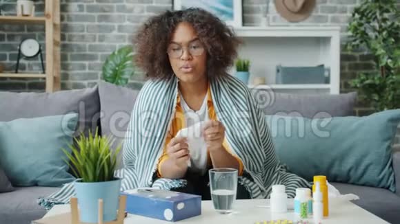 生病的非裔美国女士在家里用纸纸打喷嚏时动作缓慢视频的预览图