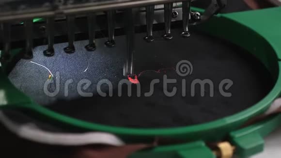 数控机器人缝纫机一种自动机器刺绣图案黑色布上有红色的线机器人在工作视频的预览图