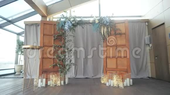 从上面的木门之间在蜡烛和蜡烛下面的一个花环上拍摄了一个遥远的婚礼祭坛视频的预览图