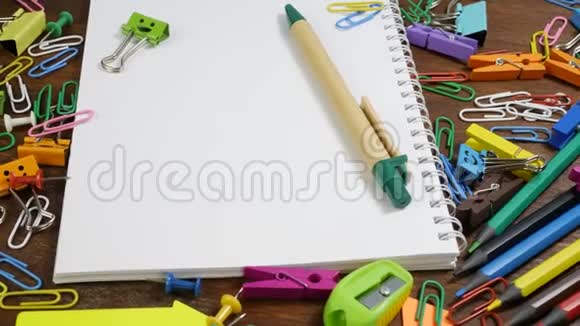 棕色木桌上的学校纸笔记本和各种文具视频的预览图