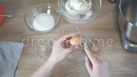 女人的手打碎了一个鸡蛋一个女人把白色和蛋黄分开烹饪视频的预览图