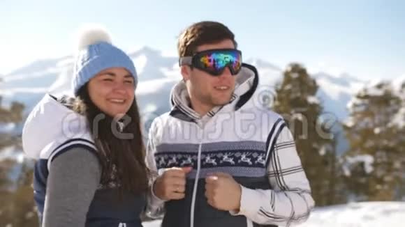 滑雪场的年轻夫妇在山顶上调情和拥抱那家伙当场就跳了起来视频的预览图