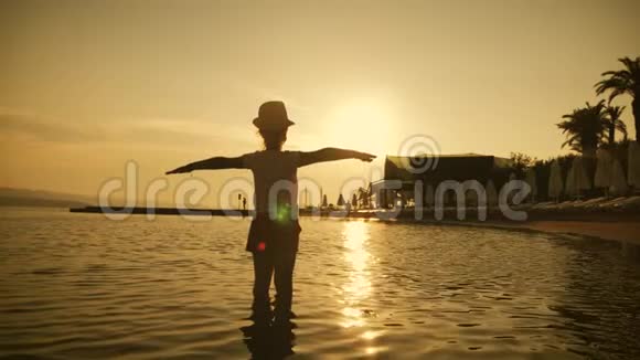 日落时分快乐的孩子在海滩上玩耍的剪影梦想着飞翔暑假和旅游理念视频的预览图