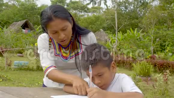 年轻的土著妇女帮助儿子做家庭作业视频的预览图