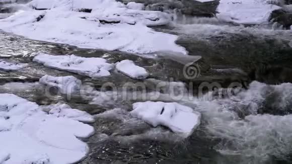 冬天的山溪山河在冬季景观的岩石附近流过冰雪视频的预览图