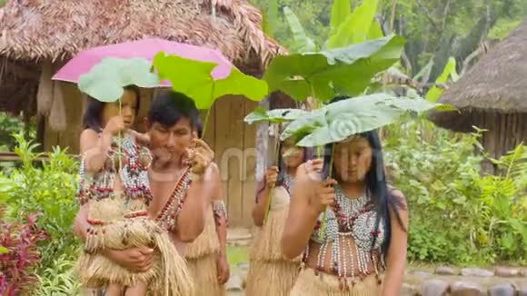 带着伞的树叶在雨中行走的土著人亚马逊雨林视频的预览图