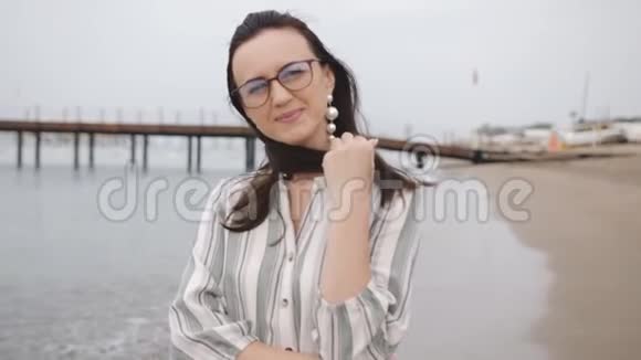 戴眼镜的女人在海滩上聊天享受散步的肖像视频的预览图