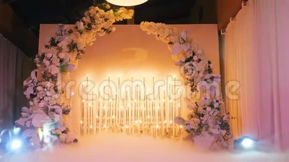 美丽的婚礼祭坛上装饰着白色的花上面有明亮的黄色灯泡上面有聚光灯的蒸汽视频的预览图