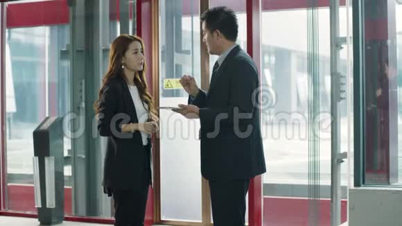 在电梯厅说话的亚洲商人视频的预览图