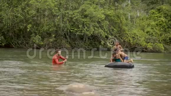 电影制作人正在用他的gopro拍摄土著儿童在水中玩耍视频的预览图