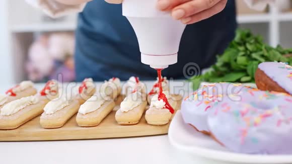 专业的面包师女士手臂在糕点上涂上甜酱4k龙红相机视频的预览图