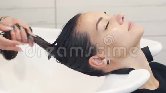 收拢理发师把护发素应用于女性湿发动作缓慢视频的预览图
