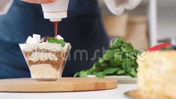 把女厨师的双手放在美味的甜点上浇上甜红4k龙红相机视频的预览图