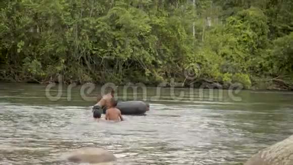 土著男孩玩浮胎在当地的河流里游泳视频的预览图