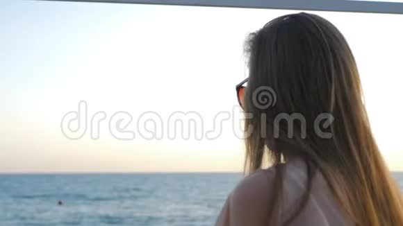 年轻漂亮女孩吃玉米的肖像在大海上吃零食视频的预览图