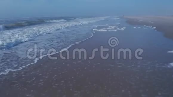 在海滩上飞过海岸线的鸟瞰图视频的预览图