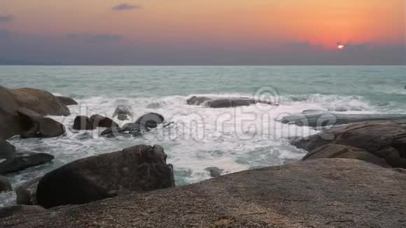 在史诗般的夕阳背景下海浪拍打着海岸视频的预览图