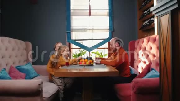 一家人坐在酒店的餐馆里喝咖啡和果汁吃葡萄视频的预览图