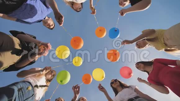 一群朋友向天空释放五颜六色的气球视频的预览图
