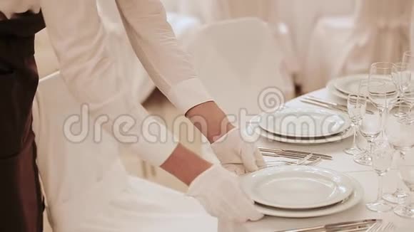 侍者戴着白手套整齐地摆了一张婚桌专业的服务员移动和伸直盘子和食物视频的预览图