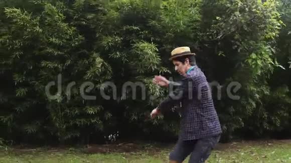 一个戴着帽子在后院玩戏耍的人骑着独轮车视频的预览图