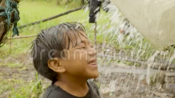 一张土著小男孩被淋湿的照片视频的预览图