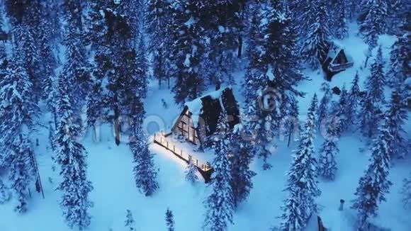 山上的小茅屋被雪覆盖着用无人驾驶飞机飞过森林和美丽的小屋视频的预览图