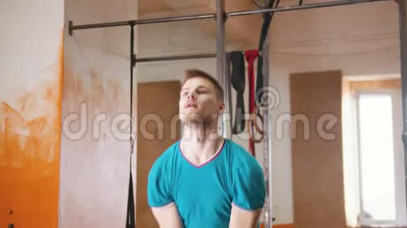 室内运动训练一个穿着蓝色衬衫的帅哥蹲着手里拿着体重视频的预览图