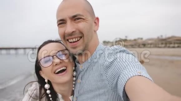 欢乐情侣沙滩上拍自拍画像视频的预览图