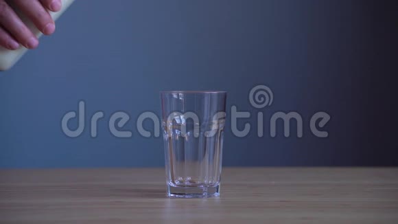 在木桌上用杯子倒牛奶视频的预览图