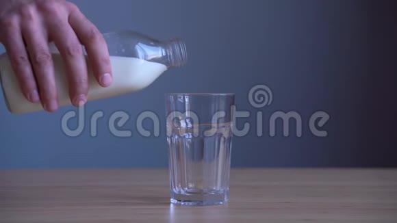 用手在木桌上倒牛奶视频的预览图