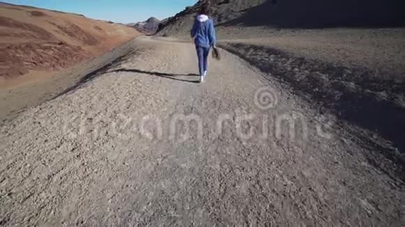 从泰德火山下来的旅行者的后景穿牛仔布的女人徒步旅行火山景观广角视频的预览图