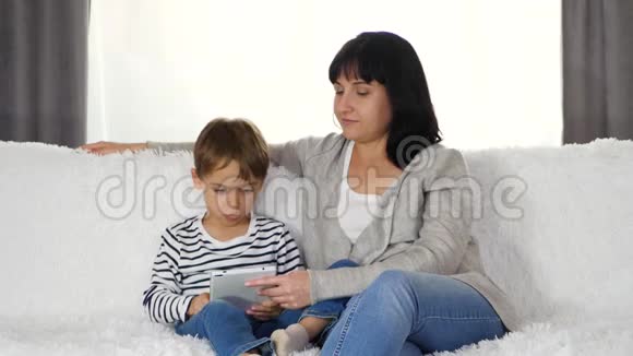 幸福的家庭母子在一起玩或看平板电脑上的电影现代的概念视频的预览图